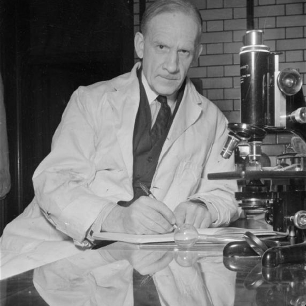 1944年、Oxford大学の研究室で顕微鏡のそばに座る化学者Robert Robinson。